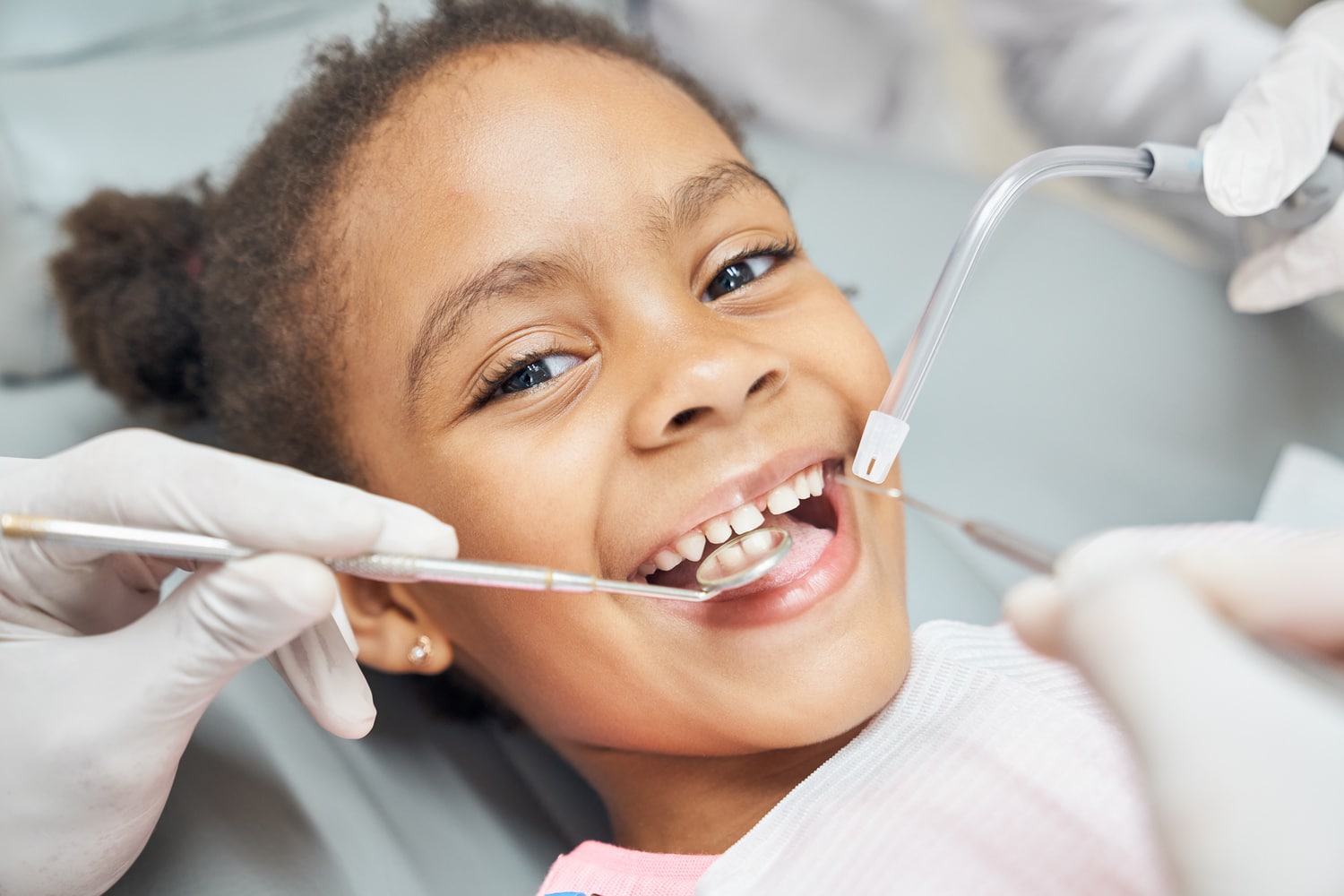 Cute african girl during dental treatment at modern clinic Little girst at her first dental appointment in PAcific Grove Ca