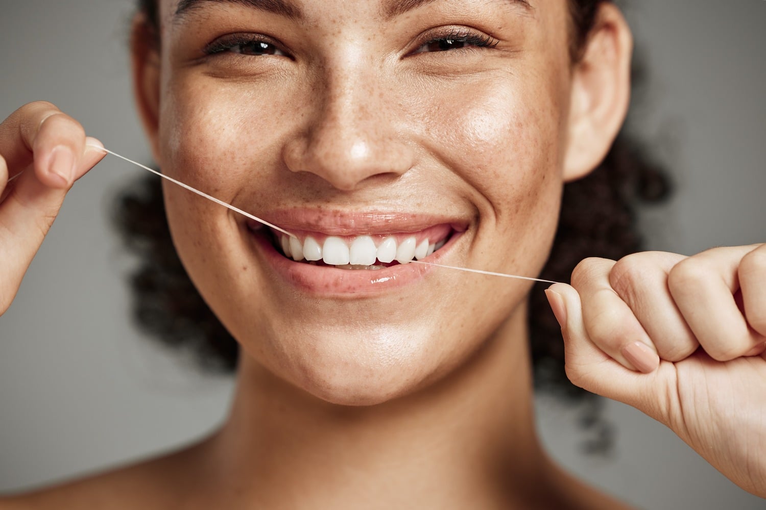 AdobeStock_560698304 v2 Woman practices good hygiene by flossing after a dental cleaning in Pacific Grove