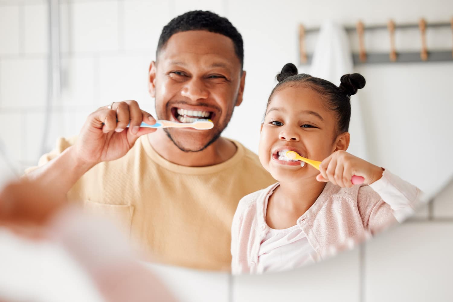 AdobeStock_608957878 v2 Dad and daughter prepare for his Child's Next Dental Cleaning in PAcific Grove by brushing their teeth together